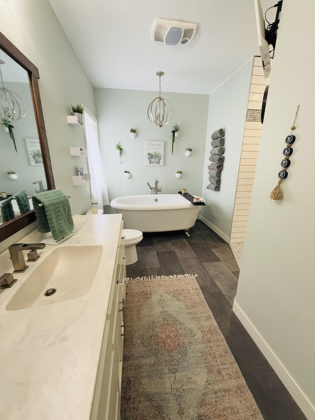 bathroom featuring vanity, a notable chandelier, and a tub