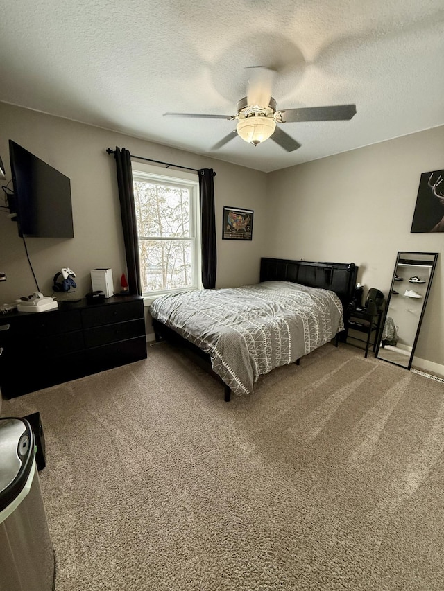 bedroom with a textured ceiling, ceiling fan, and carpet