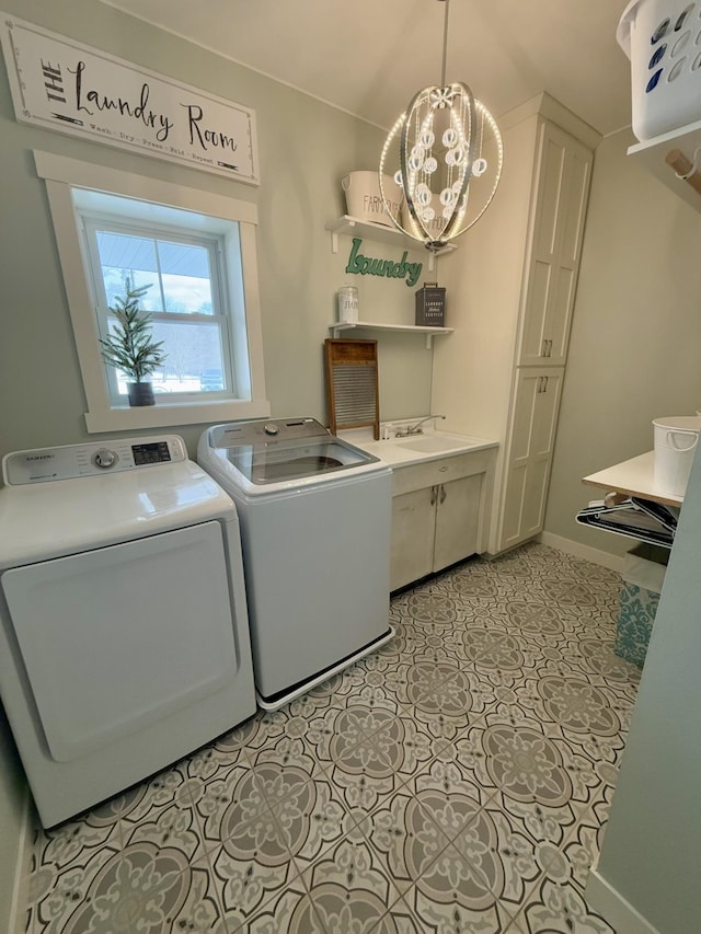 clothes washing area featuring cabinets, light tile patterned floors, independent washer and dryer, and a chandelier