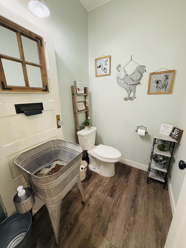 bathroom with hardwood / wood-style flooring and toilet