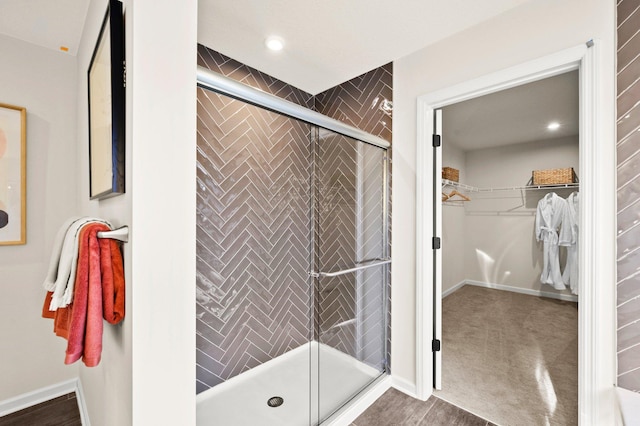 bathroom with hardwood / wood-style flooring and a shower with shower door