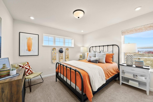 bedroom featuring light carpet and multiple windows