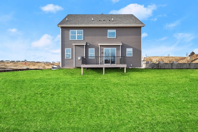 back of property with a wooden deck and a lawn