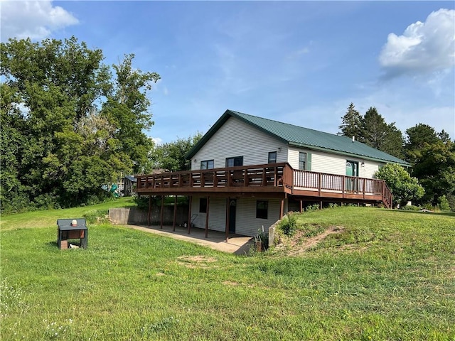 rear view of house with a patio, a deck, and a yard