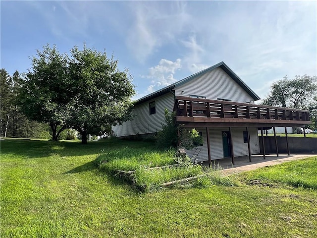 back of property with a lawn and a deck