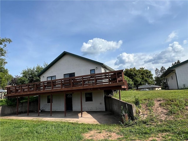 back of property with a patio, a lawn, and a wooden deck