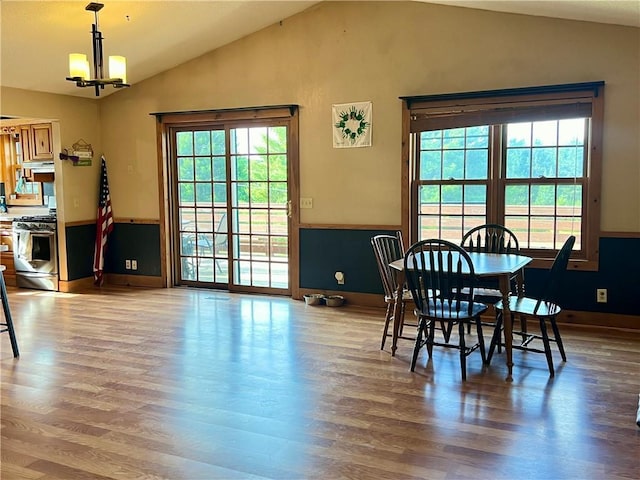 dining area featuring wood-type flooring, lofted ceiling, and a chandelier