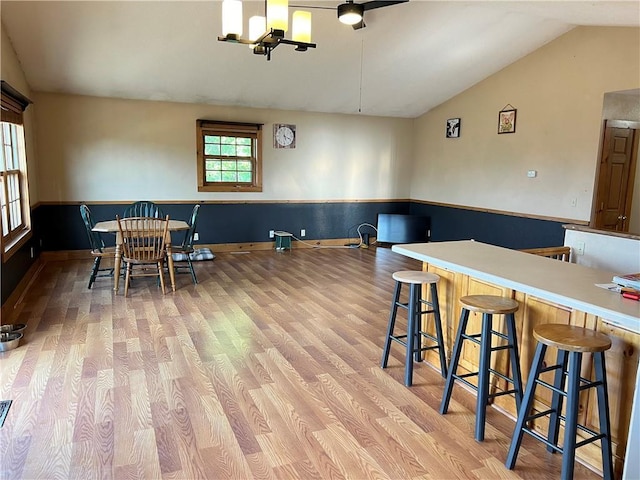 dining space featuring light hardwood / wood-style floors, a chandelier, and vaulted ceiling