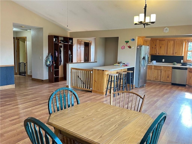 dining room featuring light hardwood / wood-style flooring, a notable chandelier, and lofted ceiling