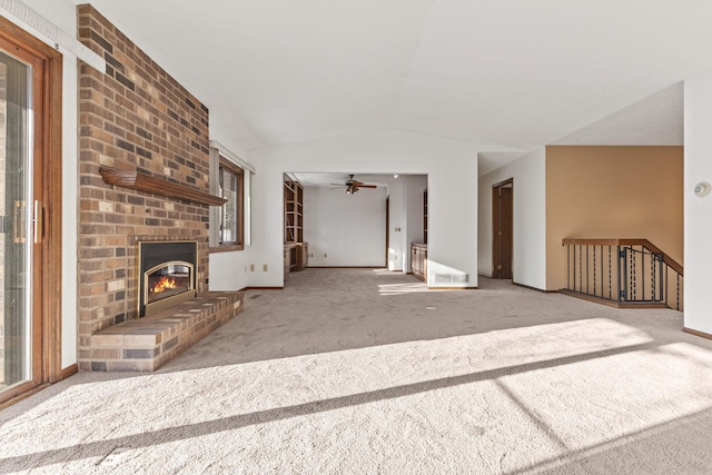 unfurnished living room with ceiling fan, light colored carpet, a fireplace, and vaulted ceiling