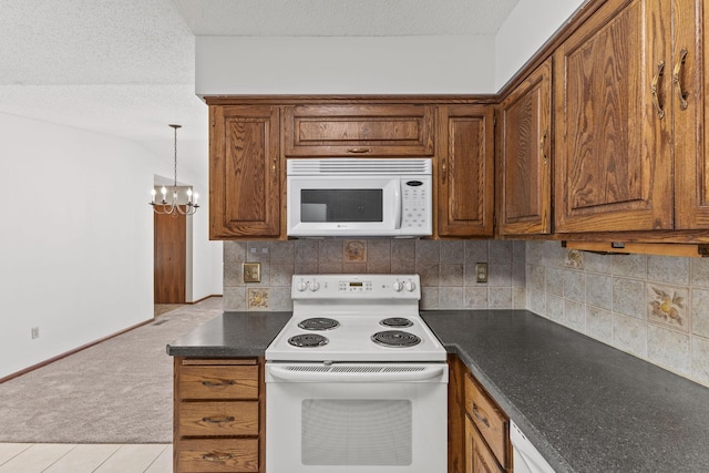 kitchen featuring light colored carpet, a textured ceiling, a notable chandelier, white appliances, and decorative backsplash