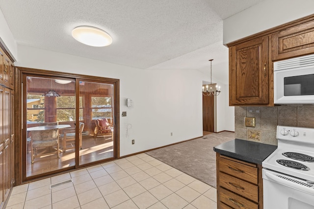 kitchen with pendant lighting, white appliances, backsplash, light carpet, and a chandelier