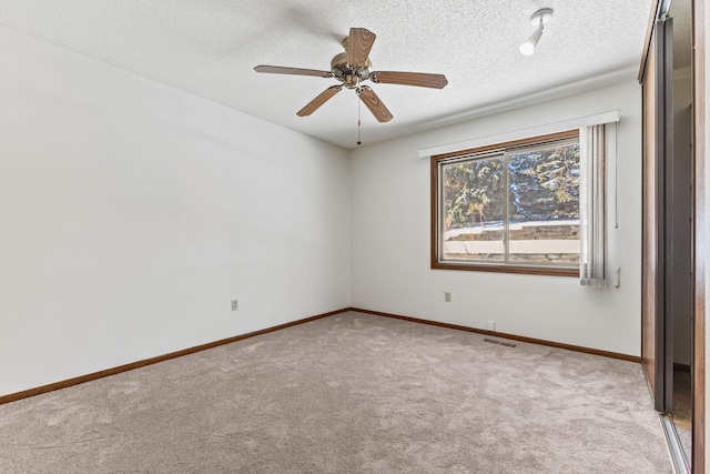 carpeted empty room featuring ceiling fan and a textured ceiling