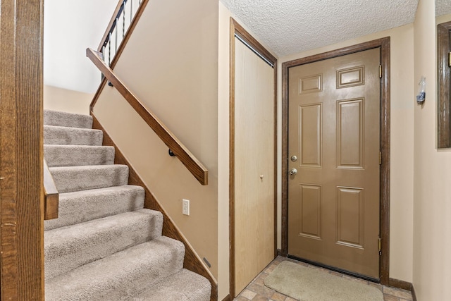 stairway with a textured ceiling