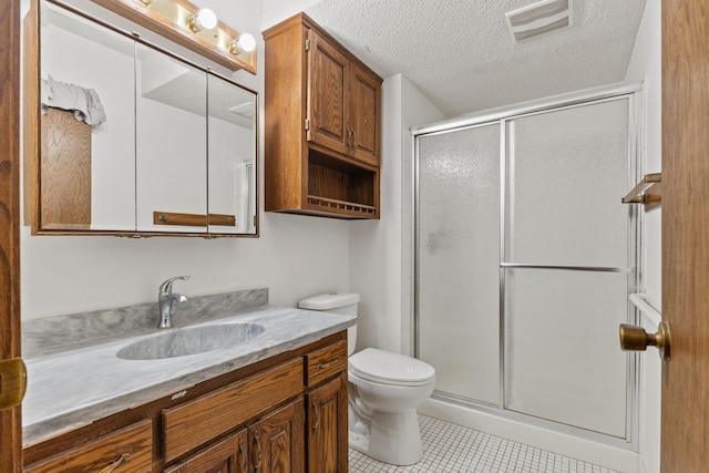 bathroom featuring toilet, a shower with shower door, a textured ceiling, vanity, and tile patterned flooring