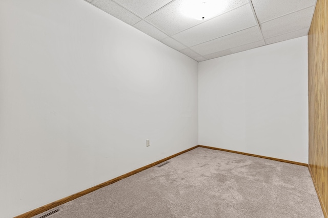 empty room with a paneled ceiling and carpet flooring