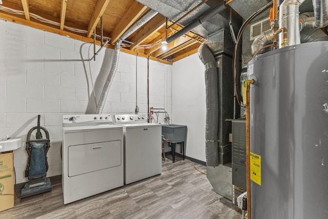 laundry room featuring washing machine and clothes dryer, sink, and water heater