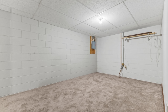 basement with light colored carpet, electric panel, and a drop ceiling