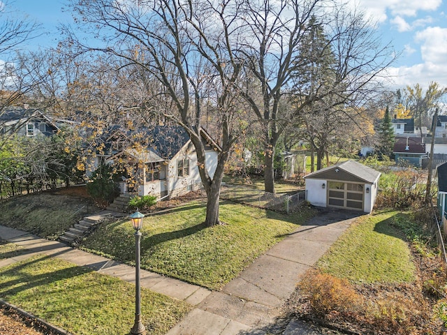 view of front of property with a garage, an outbuilding, and a front lawn