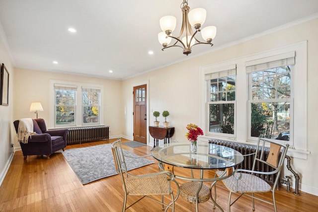 dining space featuring radiator heating unit, crown molding, and a healthy amount of sunlight