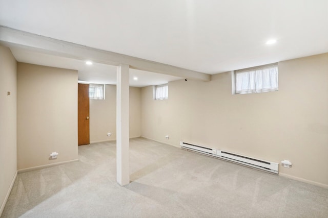 basement featuring a baseboard heating unit and light carpet