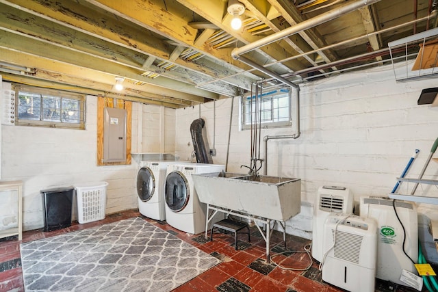 washroom with sink, electric panel, and washing machine and clothes dryer