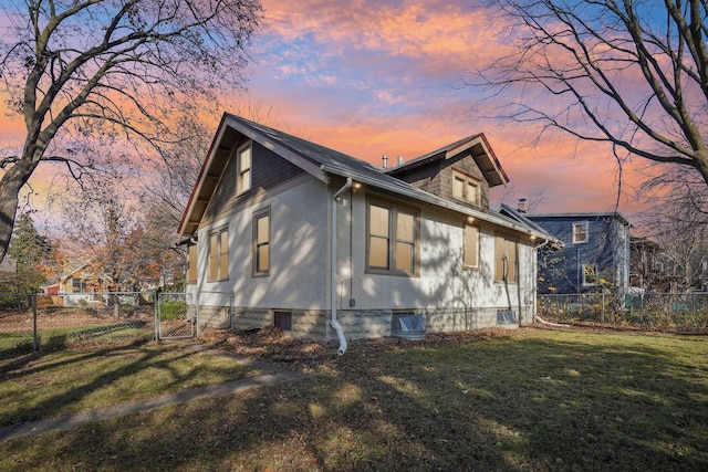 property exterior at dusk with a lawn