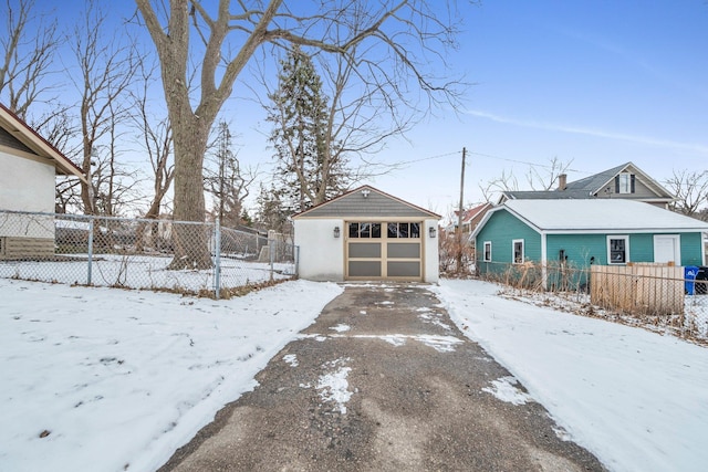 snowy yard featuring an outdoor structure and a garage