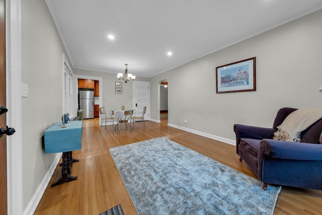 living room featuring light hardwood / wood-style floors, crown molding, and a chandelier