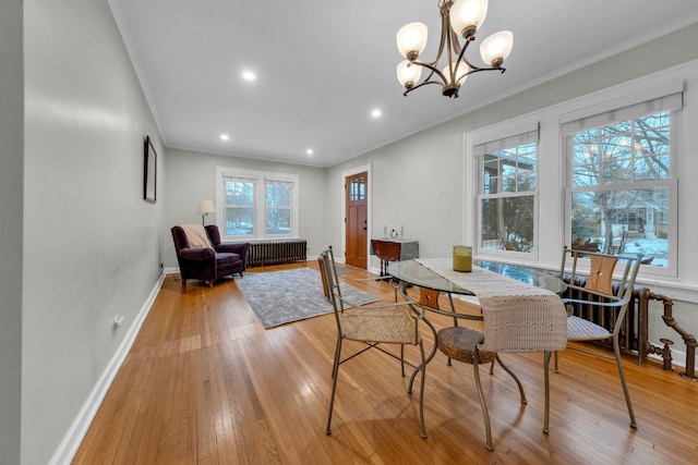 dining room with crown molding, radiator heating unit, light hardwood / wood-style floors, and a chandelier