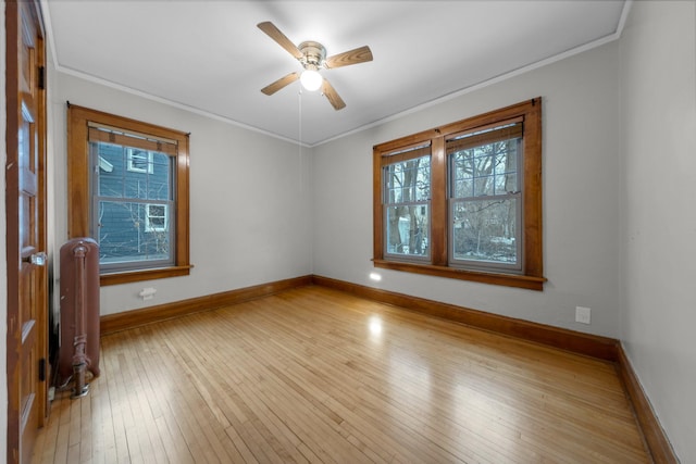 empty room with crown molding, radiator heating unit, light hardwood / wood-style flooring, and ceiling fan