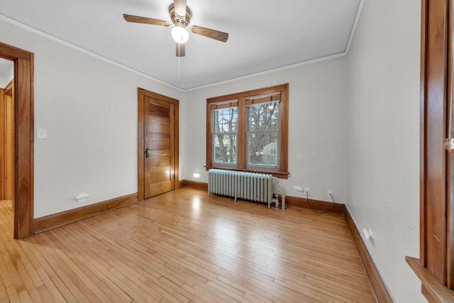 unfurnished room with light hardwood / wood-style flooring, radiator, and crown molding