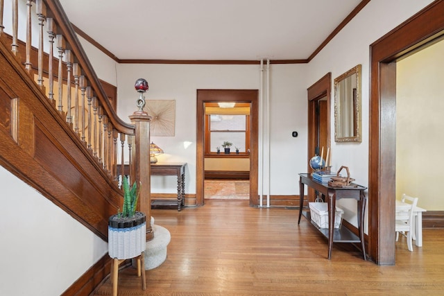 entryway featuring baseboard heating, ornamental molding, and light wood-type flooring