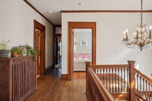 hall featuring dark hardwood / wood-style flooring, crown molding, and an inviting chandelier