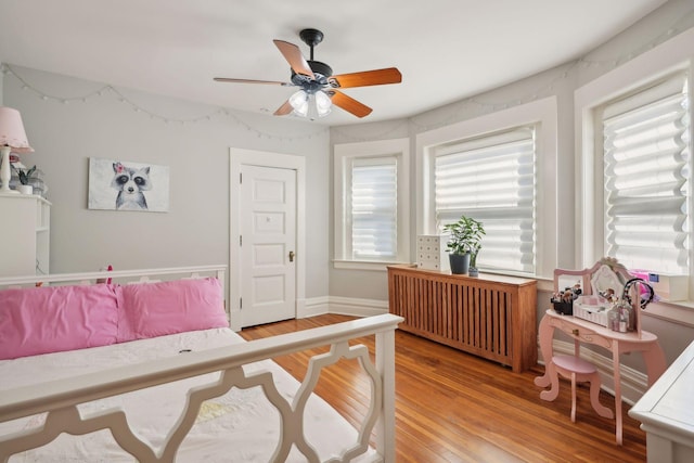 bedroom featuring radiator, ceiling fan, and light wood-type flooring