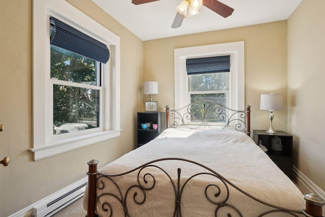 bedroom featuring multiple windows, ceiling fan, and baseboard heating