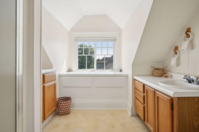 bathroom featuring vaulted ceiling and vanity