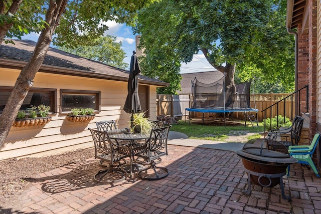 view of patio / terrace featuring a trampoline and an outdoor fire pit