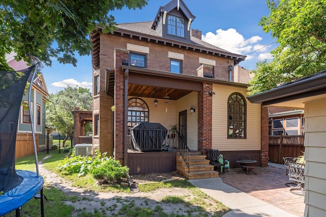 view of front of home with a trampoline, a patio area, and central air condition unit