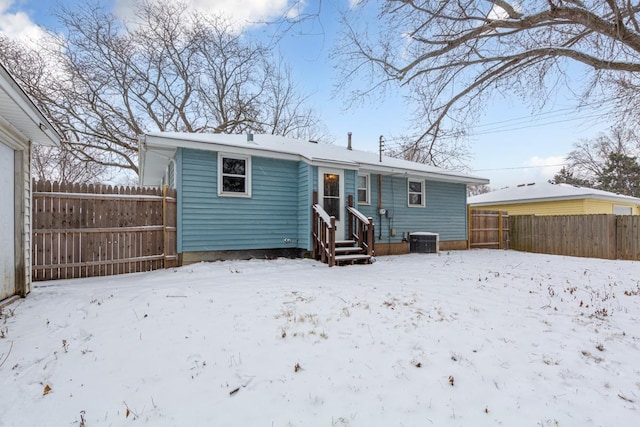 snow covered house featuring central AC unit