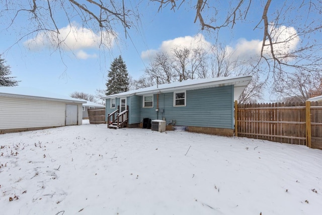 snow covered rear of property with central air condition unit