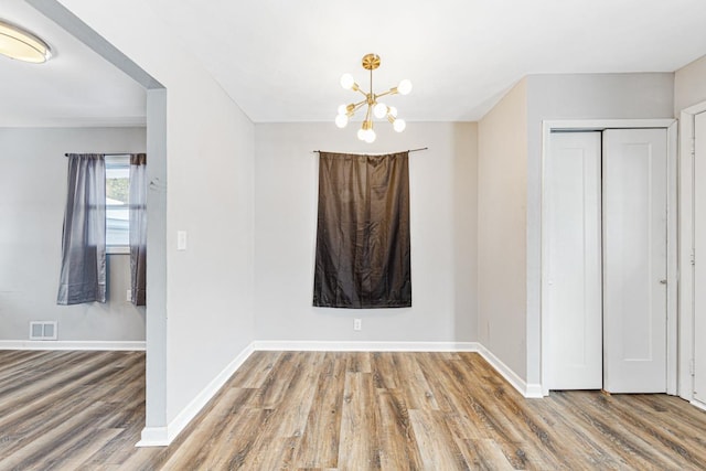 interior space featuring wood-type flooring and a notable chandelier