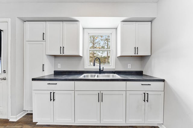 kitchen featuring sink, white cabinets, and dark wood-type flooring