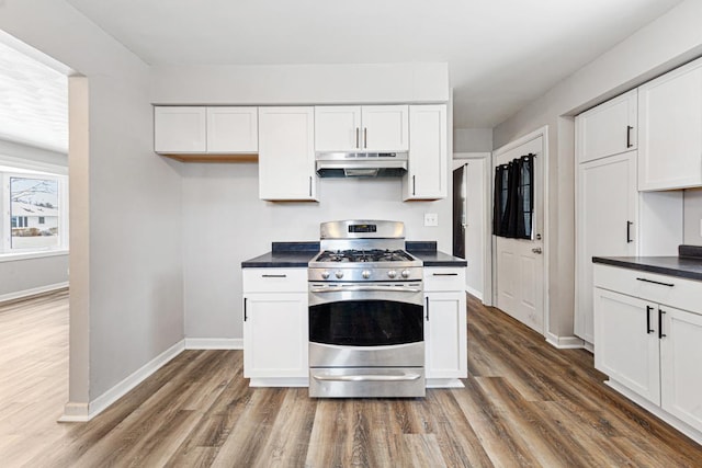 kitchen with stainless steel gas stove, white cabinetry, and dark hardwood / wood-style flooring