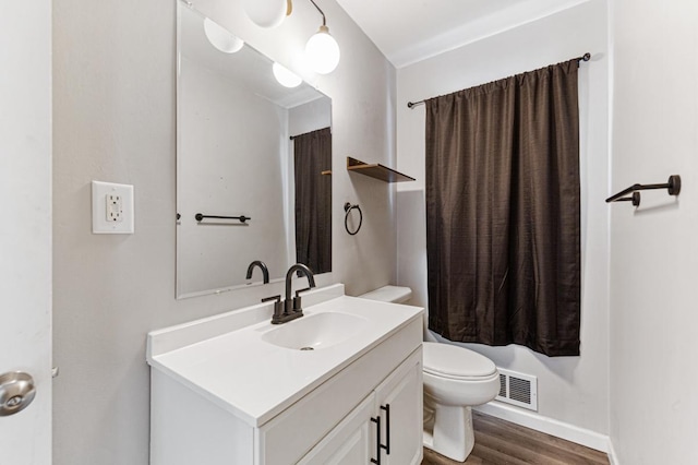 bathroom featuring vanity, toilet, and hardwood / wood-style floors