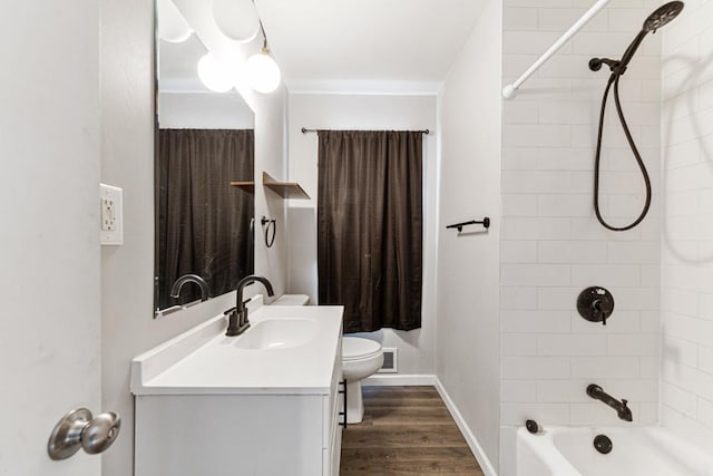 full bathroom featuring hardwood / wood-style floors, toilet, vanity, and tiled shower / bath combo