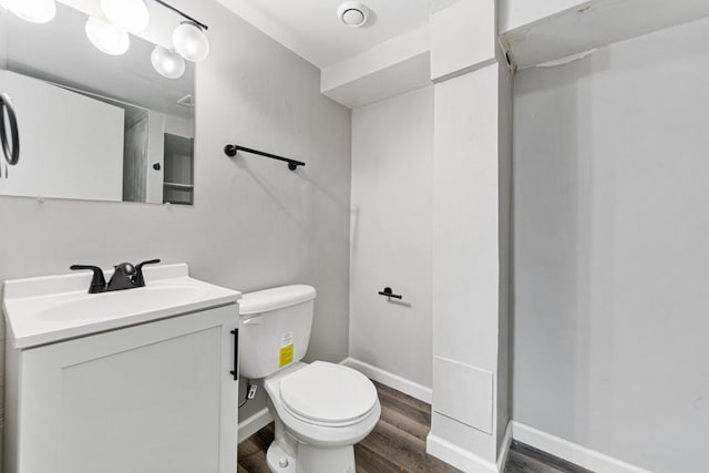 bathroom featuring wood-type flooring, toilet, and vanity