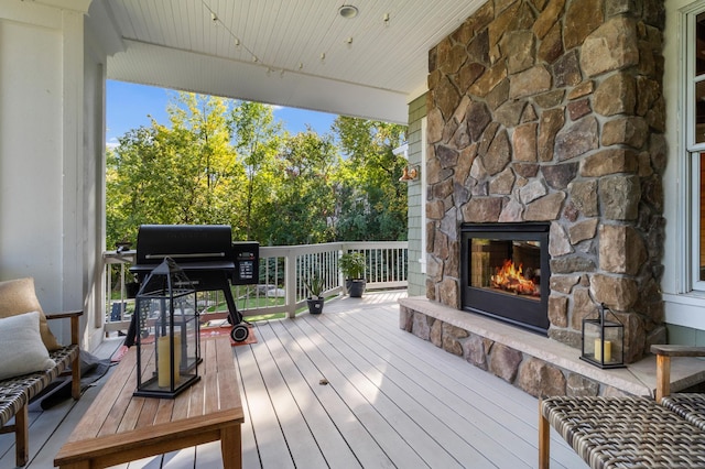 wooden deck with an outdoor stone fireplace