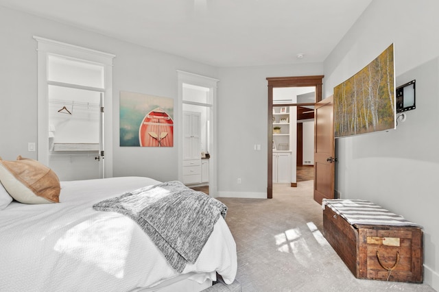 bedroom featuring light colored carpet, a spacious closet, and a closet