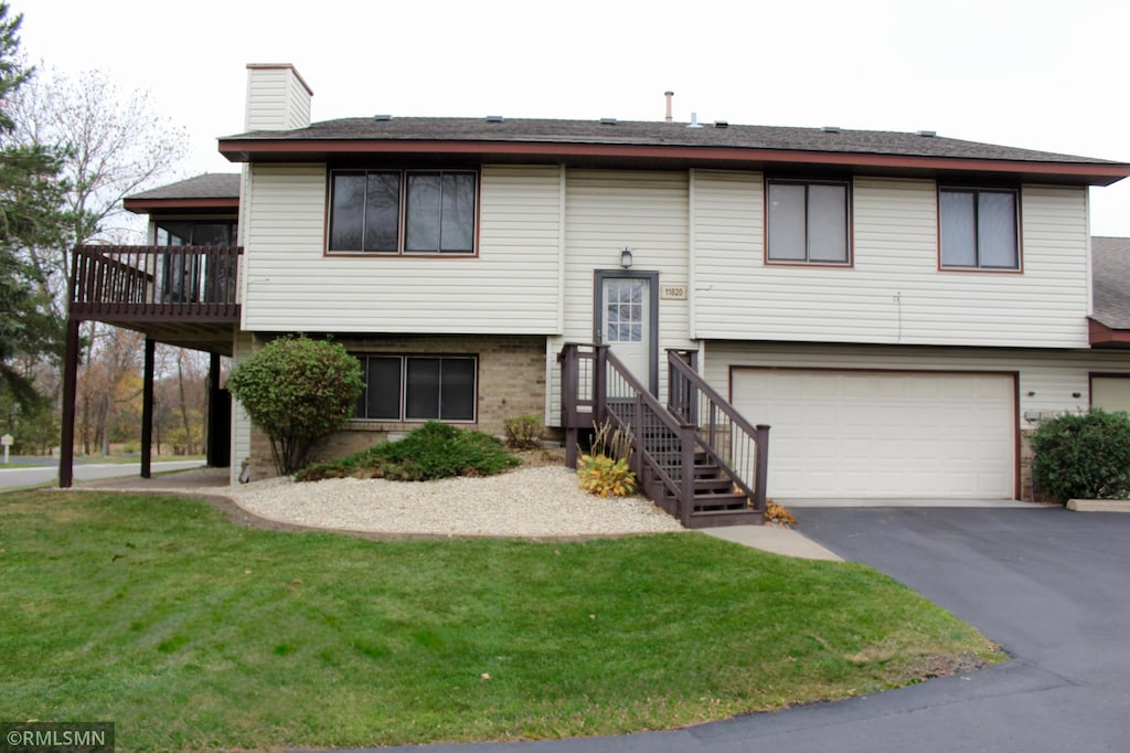 bi-level home with a garage and a front yard